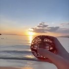 Tranquil sunset seascape with large rock and misty water