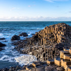 Scenic coastline with hexagonal basalt columns and crashing waves