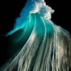 Towering Wave with Frothy White Foam against Dark Background