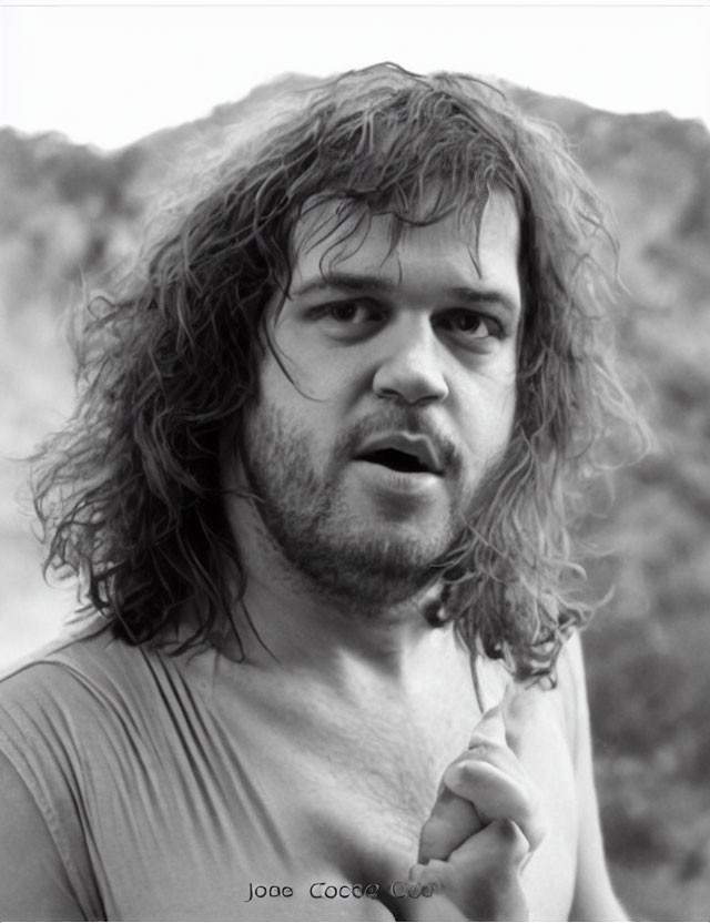 Monochrome portrait of man with curly hair and intense gaze