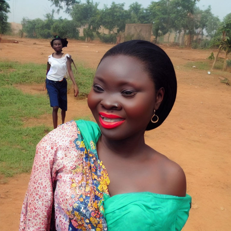 Smiling woman with red lipstick and hoop earrings, person walking on dirt road with trees and huts