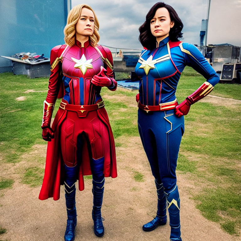 Two people in superhero outfits against cloudy sky