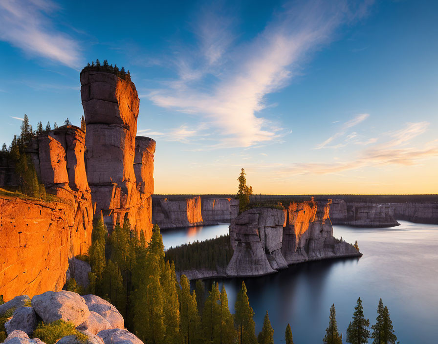 Tranquil lake at sunset with sandstone cliffs and sparse greenery