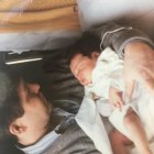 Tranquil scene: Older child guards sleeping newborn