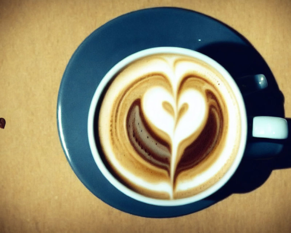 Cappuccino with Heart Latte Art and Coffee Beans on Beige Surface