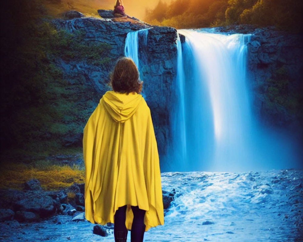 Person in Yellow Cloak Facing Majestic Waterfall at Sunset