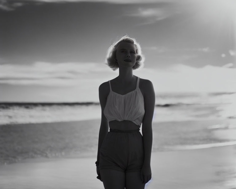 Monochrome image of woman on beach at sunset