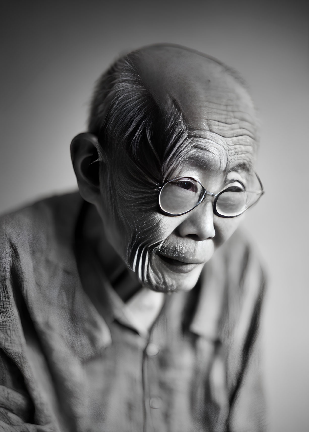 Elderly person with glasses and deep wrinkles in contemplative black and white portrait