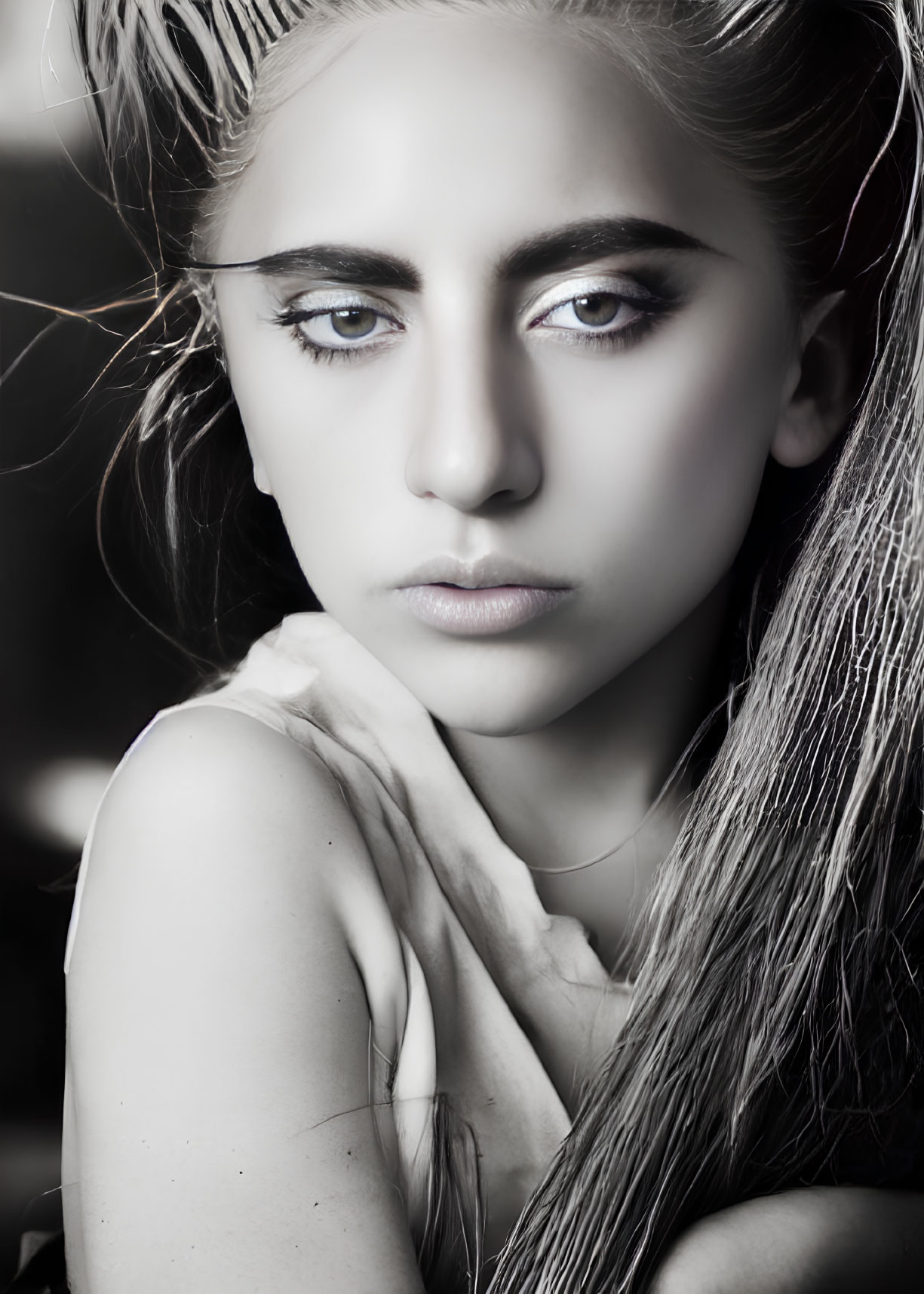 Monochrome close-up of woman with striking makeup and intense gaze