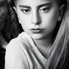 Monochrome close-up of woman with striking makeup and intense gaze