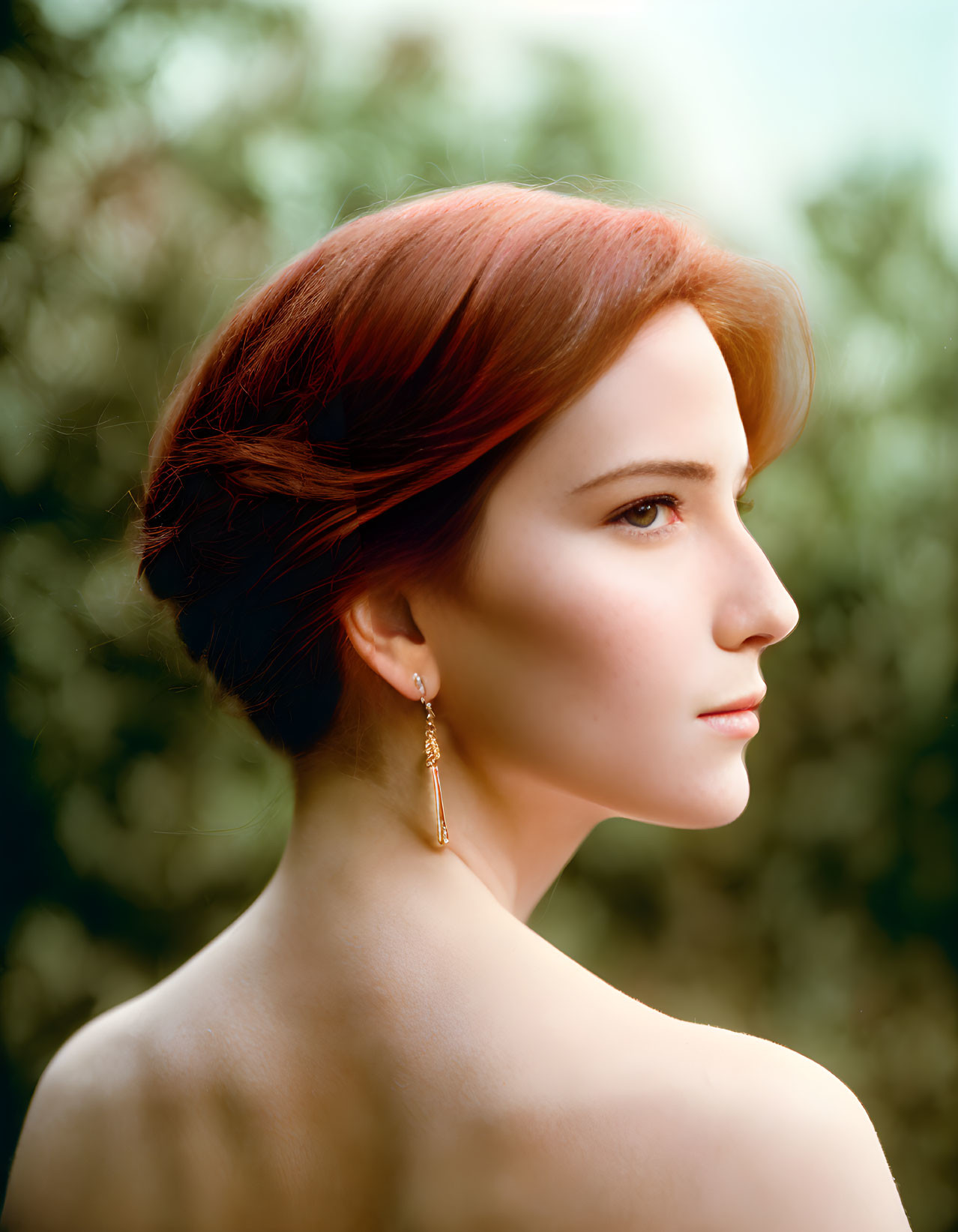 Red-Haired Woman with Updo and Earring on Soft Green Background