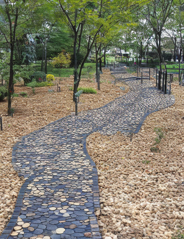 Tranquil park with winding stone pathway and green trees