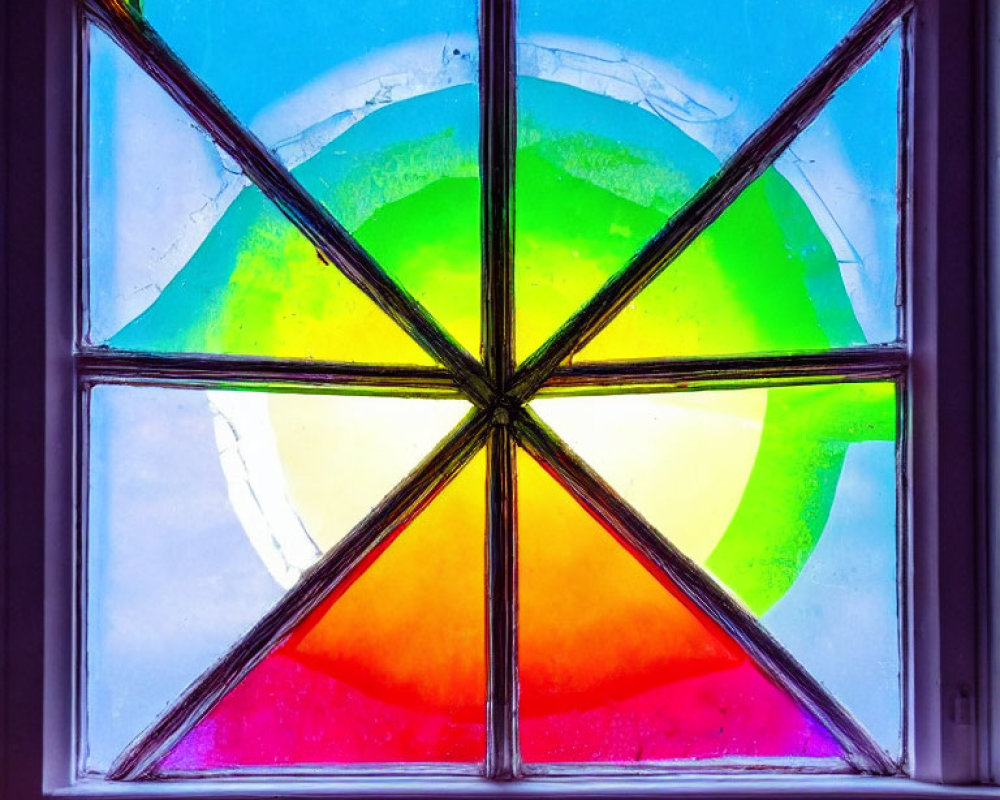 Vibrant geometric stained glass window against blue sky