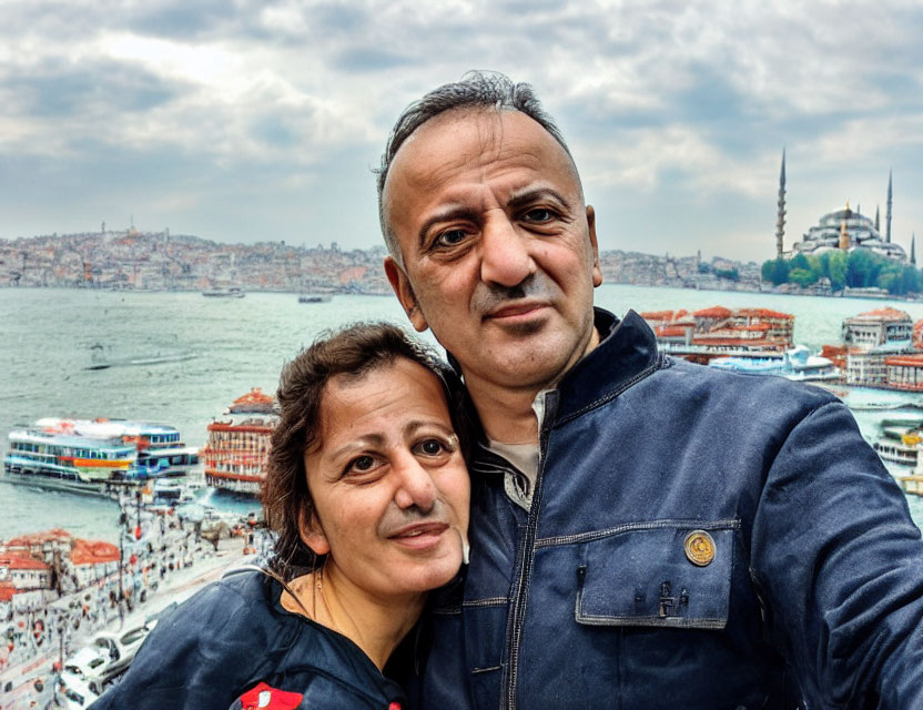 Couple selfie with city skyline, mosques, and riverfront view