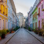 Scenic cobblestone street with colorful houses and snowfall