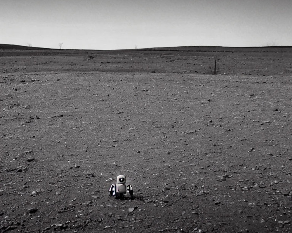 Lonely robot on barren landscape under clear sky