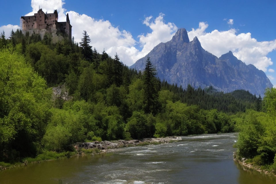 Historic castle on hilltop with river, mountain, and lush greenery