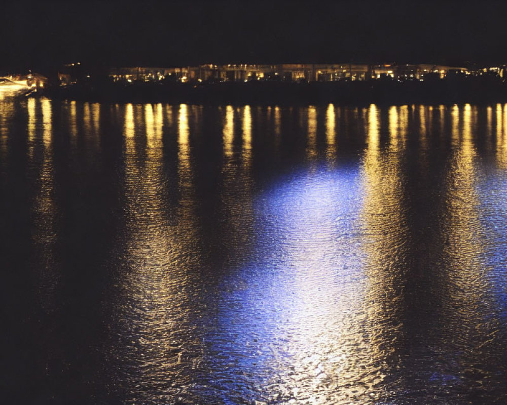 Tranquil night scene with shimmering lights reflecting on water