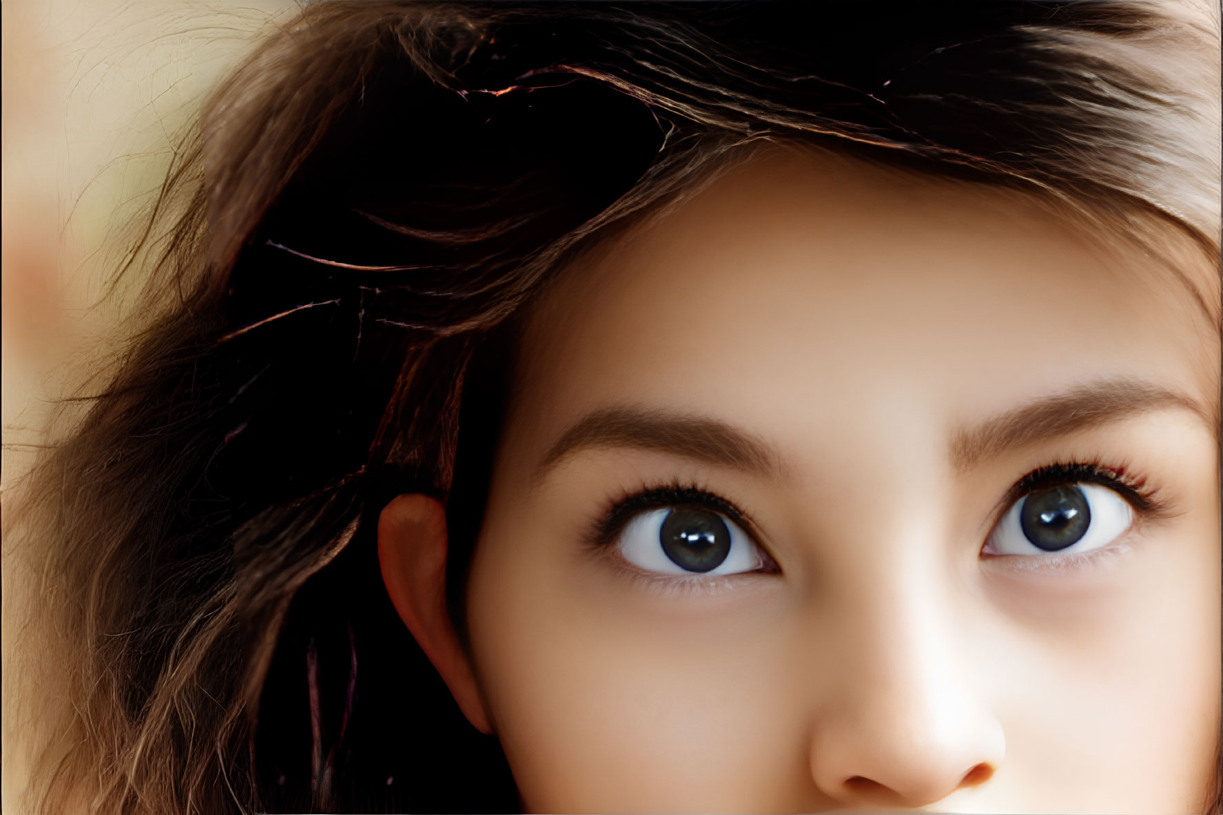 Detailed portrait of person with expressive brown eyes and fine hair strands on warm backdrop