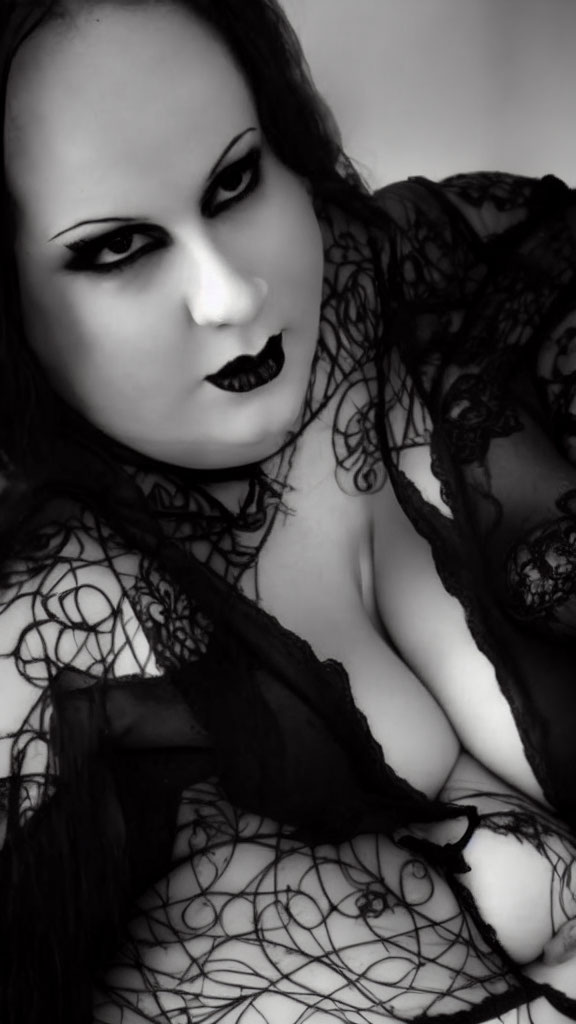 Monochrome portrait of person in dark makeup and lace attire.