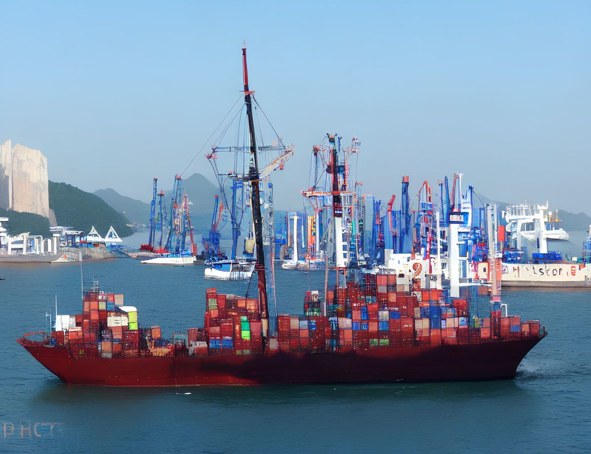 Red cargo ship with colorful containers in busy port with cranes