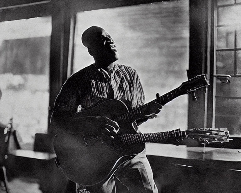 Vintage Black and White Photo of Person Playing Acoustic Guitar by Window