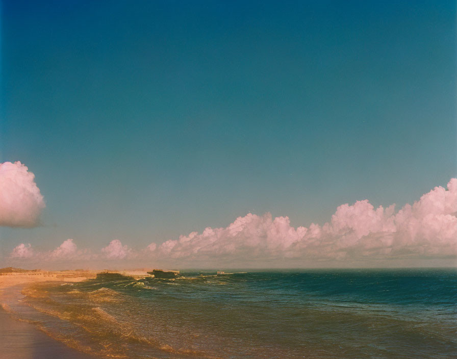 Tranquil beach landscape with fluffy clouds and gentle waves