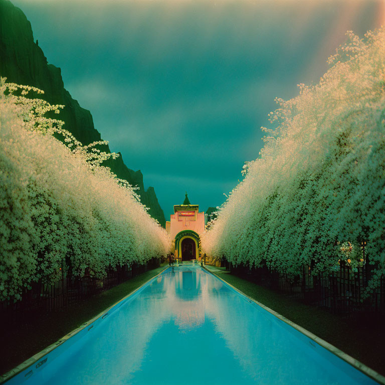 Tranquil pool mirroring lit archway and blooming trees at twilight