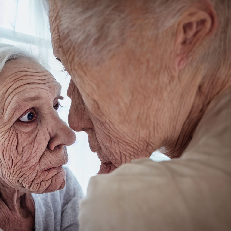 Elderly individuals touching foreheads intimately