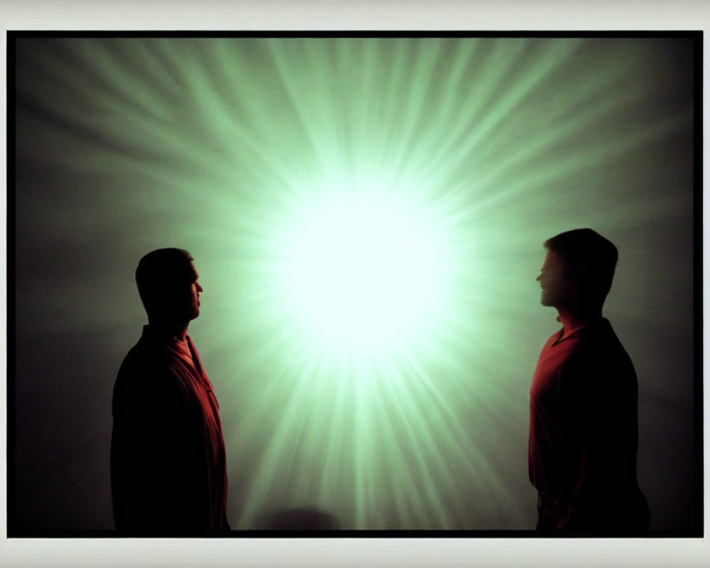 Silhouetted individuals against bright radial light pattern