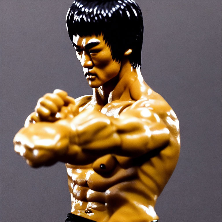 Detailed Bruce Lee action figure with muscular torso and arms, featuring serious facial expression.