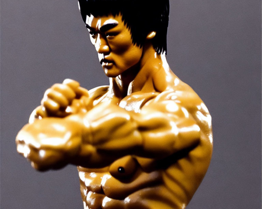 Detailed Bruce Lee action figure with muscular torso and arms, featuring serious facial expression.