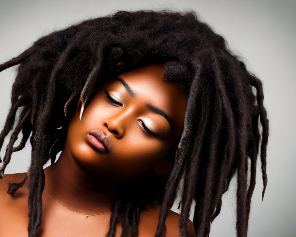 Woman with Long Dreadlocks in Calm Pose on Grey Background