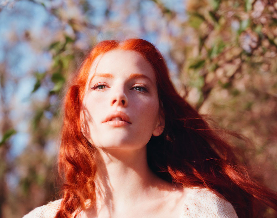 Red-haired person with fair skin gazing at blooming branches