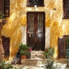 Blooming flowers and ivy on garden pathway with cottage windows