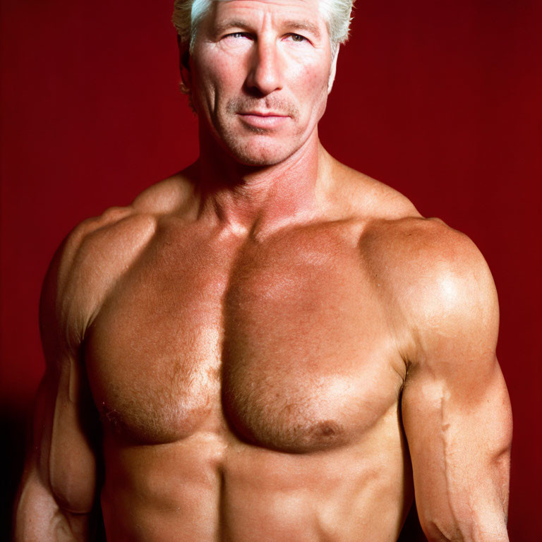 Muscular Man with Blond Hair Poses Against Red Background