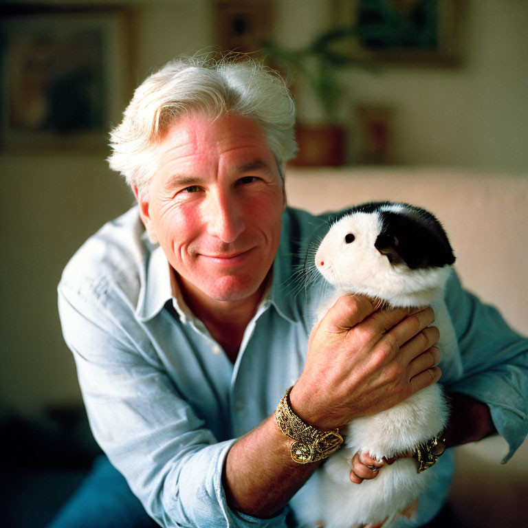 Silver-Haired Man Smiling with Guinea Pig and Blue Shirt