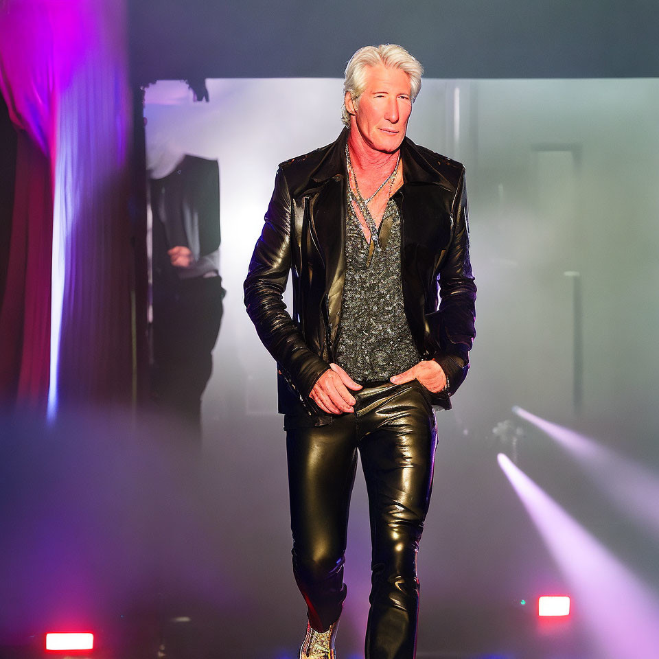 Elderly man in white hair, black leather jacket, shiny pants, and sequined shoes confidently