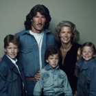 Five male figures and child in denim outfits on neutral background