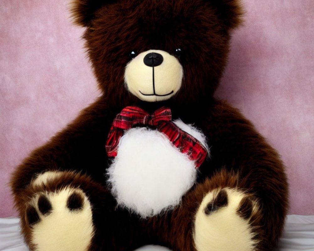 Fluffy Brown Teddy Bear with Red Bow Tie on Pink Background