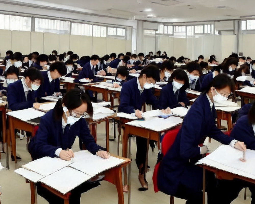 Students in uniforms writing exams at classroom desks