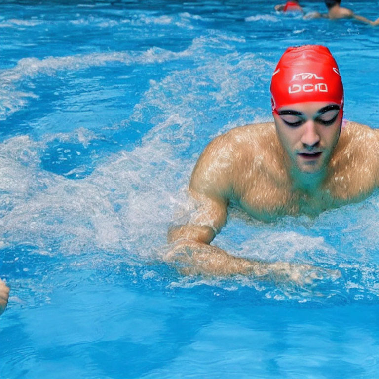 Swimmer in Red Cap Mid-Stroke in Clear Blue Pool