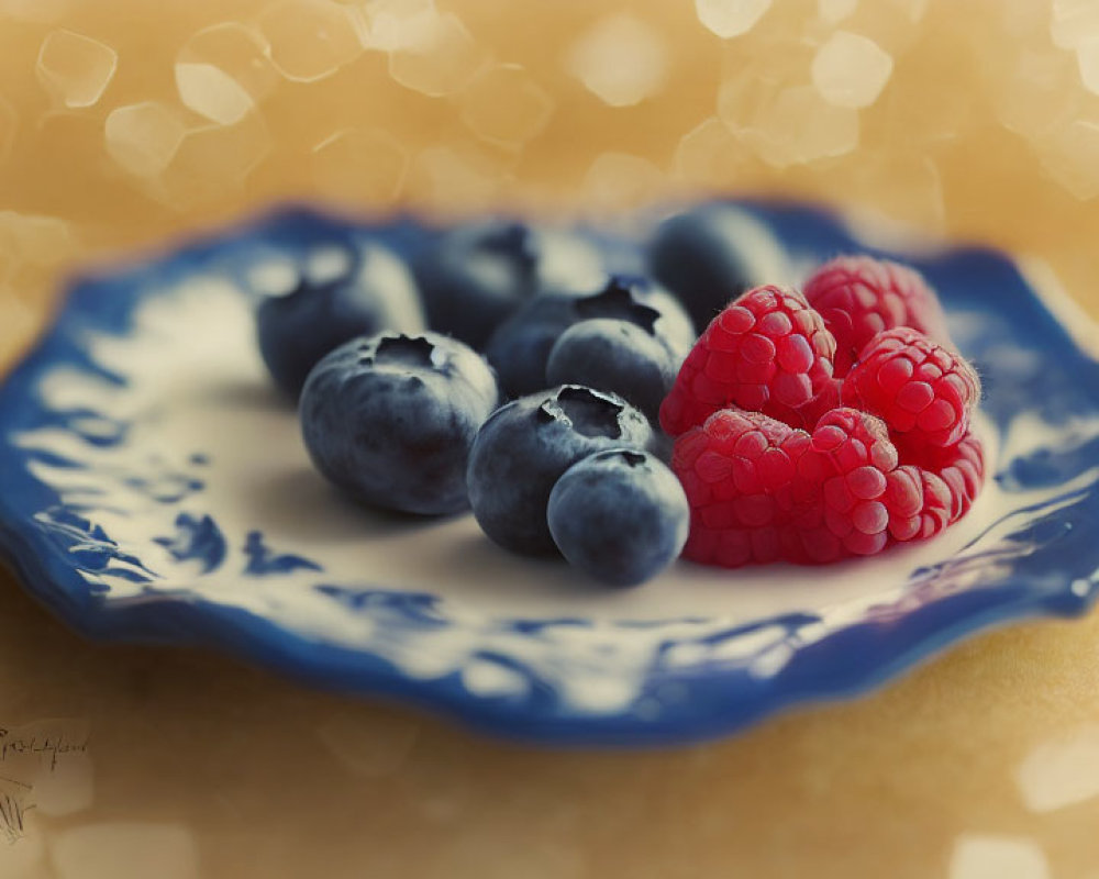 Ripe Blueberries and Raspberries on Blue Plate