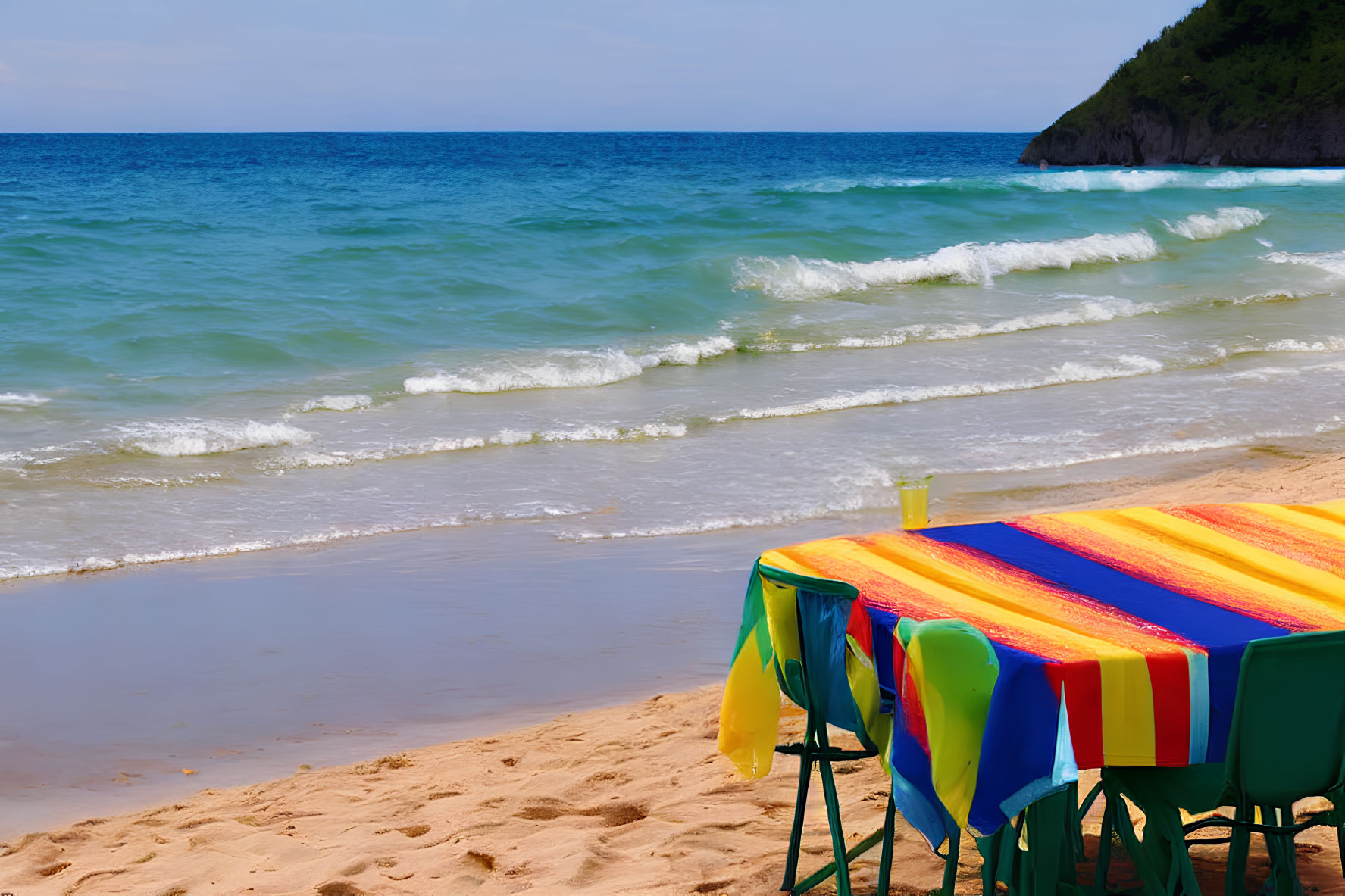 Vibrant beach table setup with waves and blue sky