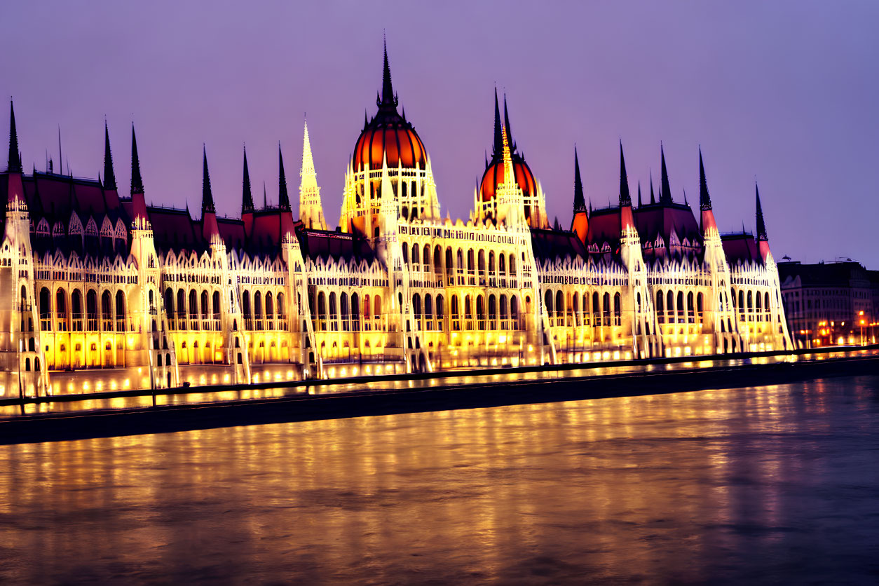 Iconic Hungarian Parliament Building at dusk reflecting in Danube River against twilight sky