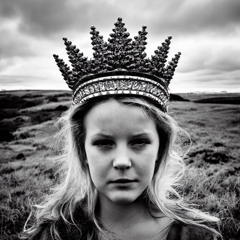 Monochrome photo of young girl in ornate crown outdoors