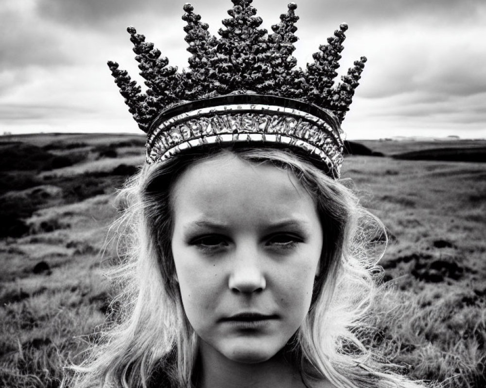 Monochrome photo of young girl in ornate crown outdoors