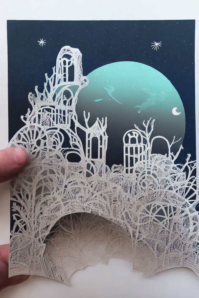 Intricate paper cut-out artwork of trees, architecture, stars, and teal moon