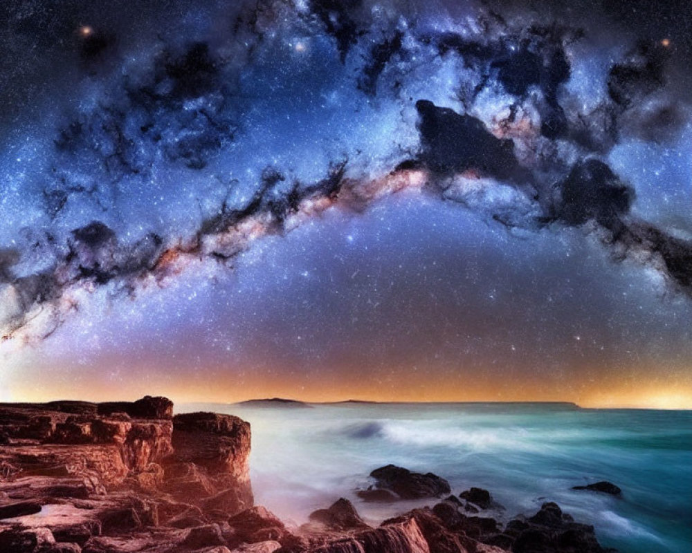 Nighttime Milky Way over rugged coastline with twilight glow