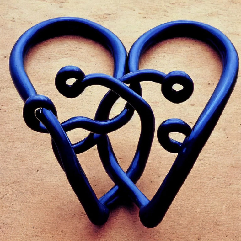 Blue Metal Double Heart-Shaped Sculpture on Beige Background